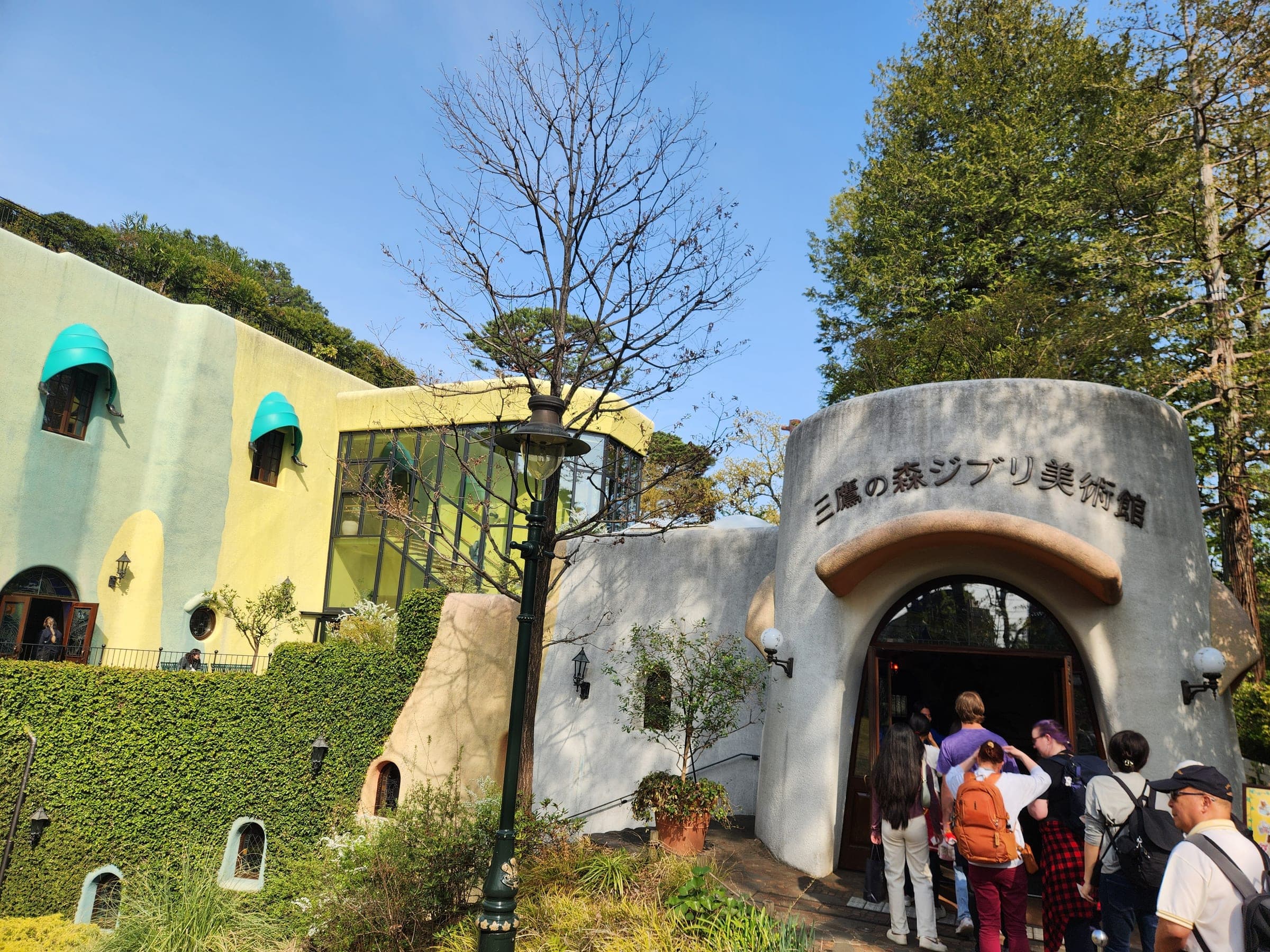 Visitors walking into the museum through the arched main entrance