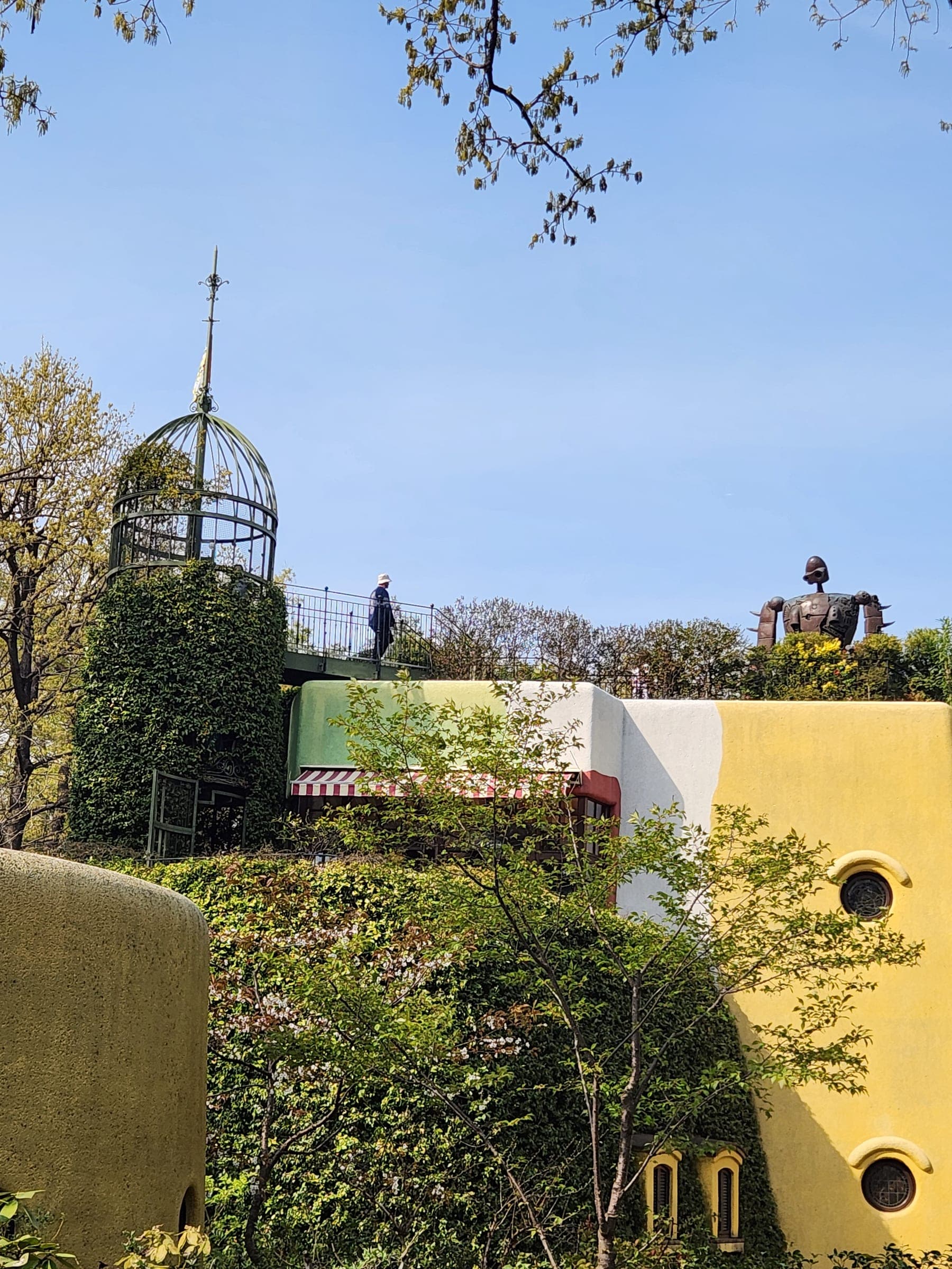 El jardín de la azotea con su torre de hierro en forma de jaula y la estatua del Robot soldado contra un cielo azul